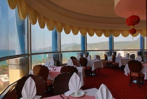 Enjoy a meal with a view from this dining area featuring a curved ceiling and large windows.
