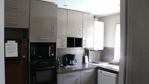 A compact kitchen with a microwave, coffee maker, and dishwasher. - Maison du Lavoir Disneyland (Bailly-Romainvilliers)