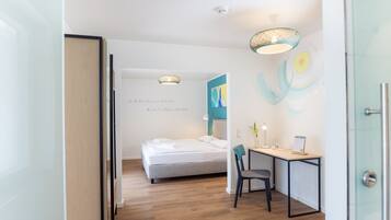 Habitación de hotel moderna con cama, escritorio y una silla. Una pared con una cita y arte abstracto.
