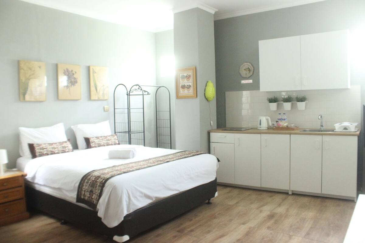Une chambre à coucher comprenant un lit, une table de chevet et un petit bureau avec une chaise.