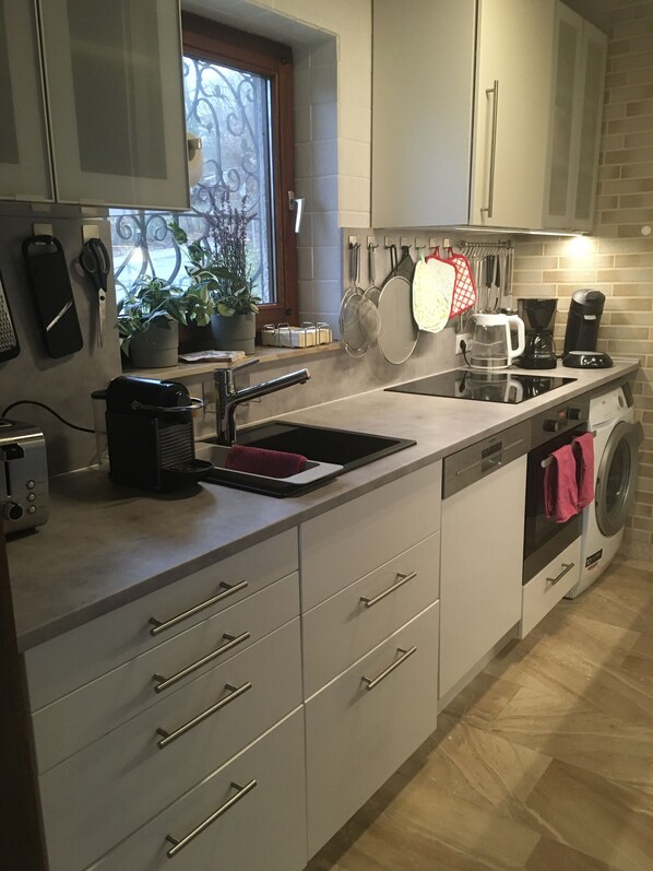 A modern kitchen with a built-in dishwasher, a coffee maker, and a sink. - House with lake view and terraces - spacious (Edertal - Bringhausen)