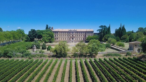 A large, historic building with a symmetrical facade, surrounded by well-maintained gardens and vineyards. - Two bedrooms for six people, swimming pool in Hérault (Roujan)