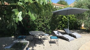 An outdoor patio area with a table, chairs, a grill, and lounge chairs under a canopy. - Two bedrooms for six people, swimming pool in Hérault (Roujan)