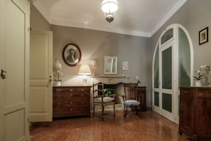 Une pièce avec une cheminée, un miroir, une lampe et une chaise.