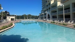 A large swimming pool with lounge chairs and a multi-story building in the background. - Coastal Soul Beach Seascape Resort Pools (Miramar Beach)