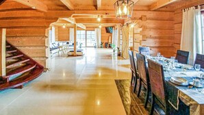 A spacious wooden interior with a dining area set for a meal, a staircase, and a view through a large window. - 4 bedroom stunning home in Ustka (Ustka)