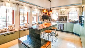 A modern kitchen with a central island, bar stools, and a view of the outdoors. - 4 bedroom stunning home in Ustka (Ustka)