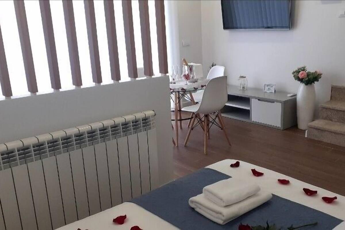 Une chambre d’hôtel avec un lit, un bureau, une chaise, une télévision et un escalier.
