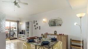 Ein Essbereich mit einem runden Tisch, Stühlen und einem Deckenventilator.