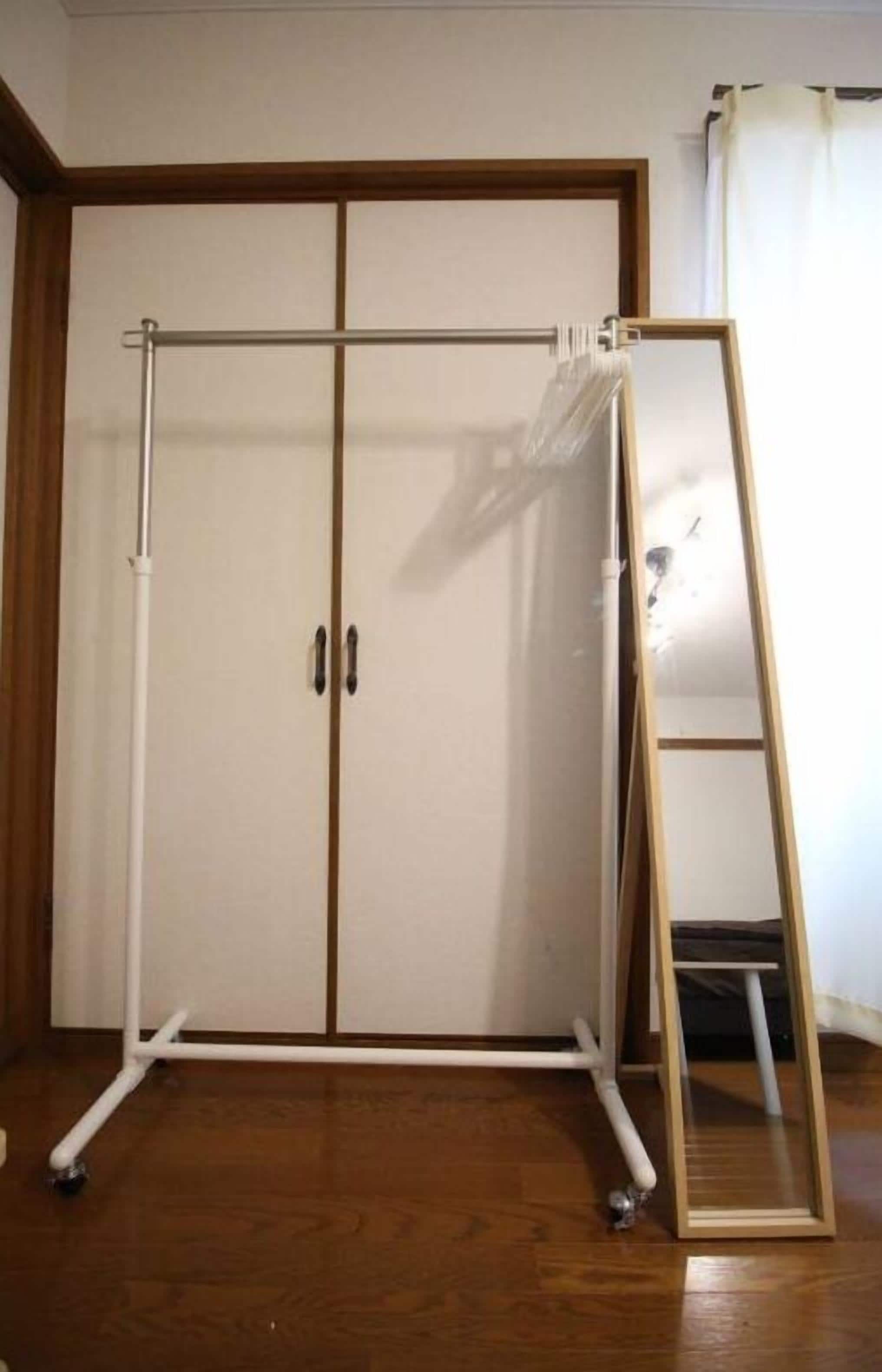 Une pièce avec une armoire, un miroir et un plancher en bois.