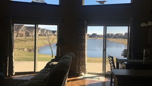 A room with large windows overlooking a lake and a view of sailboats. - Relax and make fun memories in our Vacation Home at Bridges Bay Resort (Arnolds Park)