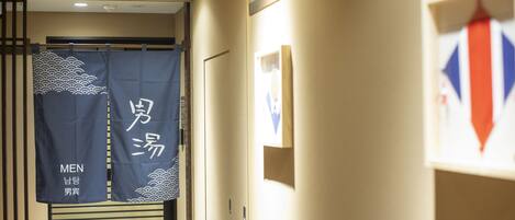 A hallway with a sliding door, a wall-mounted picture frame, and a blue banner with text.