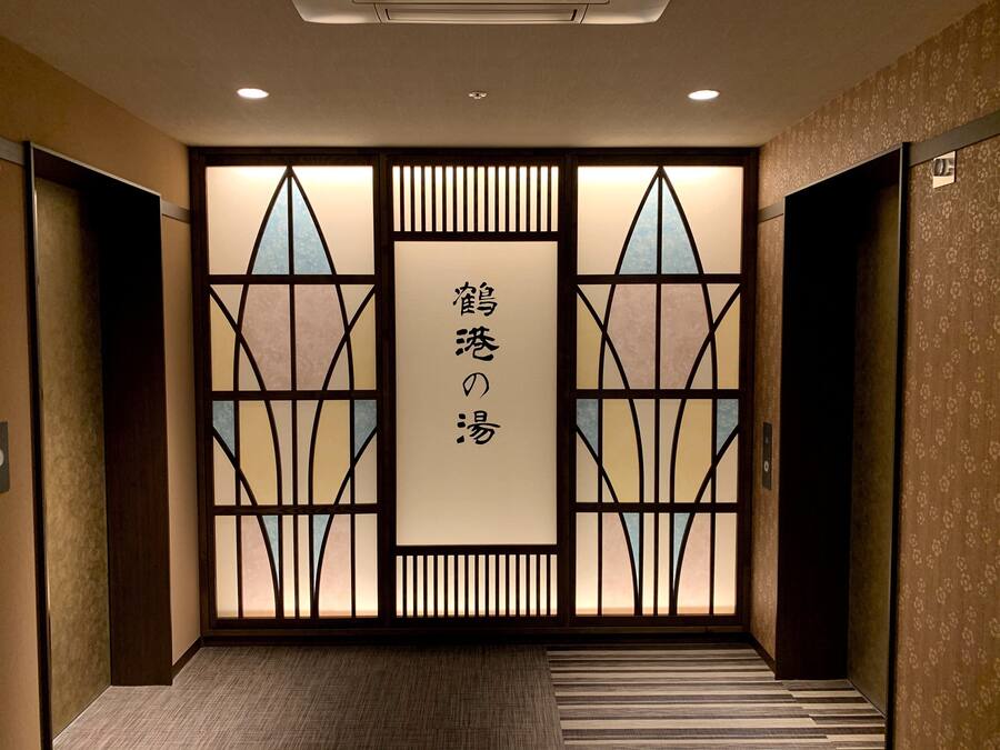 A hallway with a decorative door featuring a geometric pattern and Japanese characters.