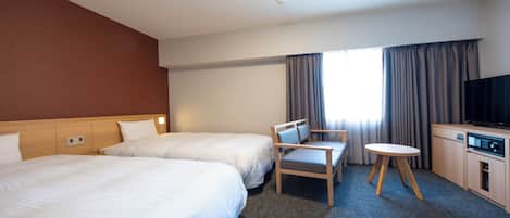 A hotel room with two beds, a desk, a chair, a television, and a window with curtains.