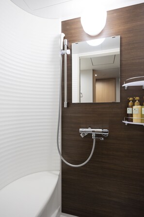 A modern bathroom with a shower, a toilet, and a vanity with a mirror and shelves for toiletries.