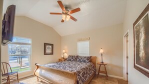 A bedroom with a large bed, a ceiling fan, two bedside lamps, a window with blinds, and a door. - Cowboy Lodge Rr94404 #4 4 Bedroom Home by RedAwning (New Braunfels)