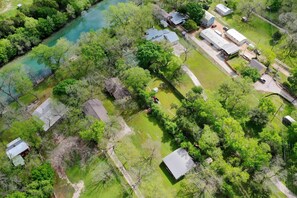 An aerial view of a residential area with multiple houses, a river, and a large building complex. - Texas Star Rr9084ts 3 Bedroom Home by RedAwning (New Braunfels)