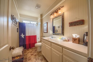 A bathroom with a shower curtain featuring a star, a sink, a mirror, and a towel rack. - Wagon Wheel Rr9084ww 3 Bedroom Home by RedAwning (New Braunfels)