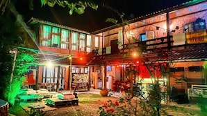 A two-story building with a patio area. - Drifter Hostel (São Sebastião)
