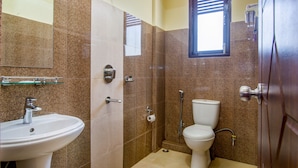 A bathroom with a sink, toilet, and shower. - Muscatel Grand Silk Route (Gangtok)