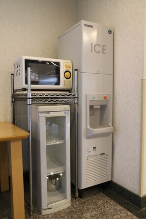 A compact kitchenette with a microwave, refrigerator, and a water dispenser.