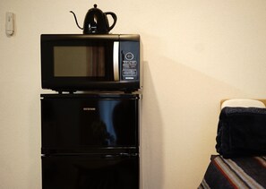 A compact kitchenette with a microwave and a refrigerator.