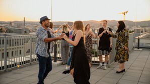 A group of people on a rooftop terrace with a cityscape view. - Rioca Vienna Posto 1 (Vienna)