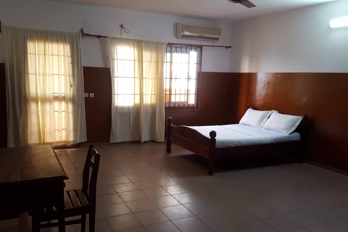 A room with a bed, a table, and a chair.