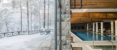 Una piscina techada, sillones reclinables de piscina