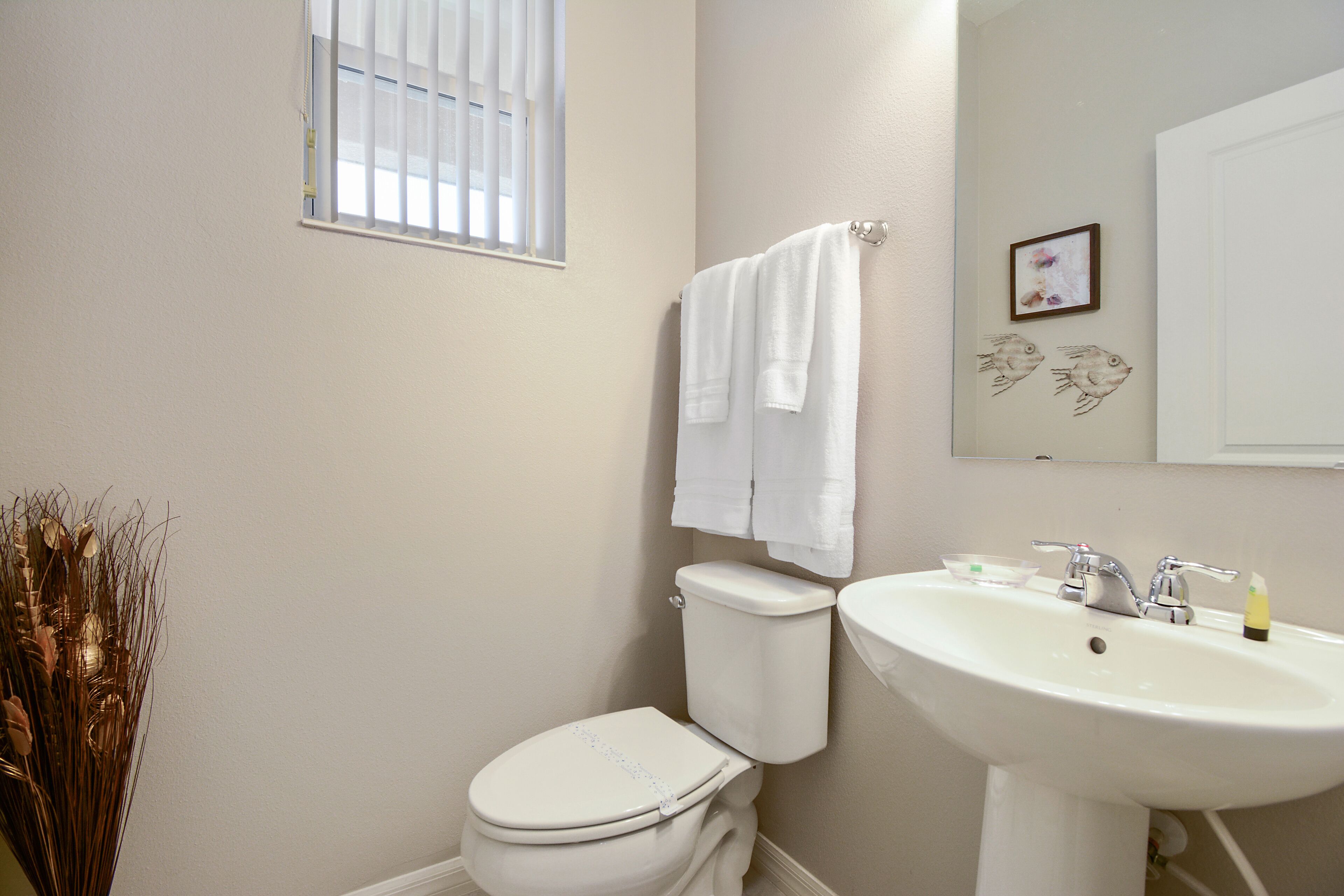 Un baño con inodoro, lavabo y ventana.