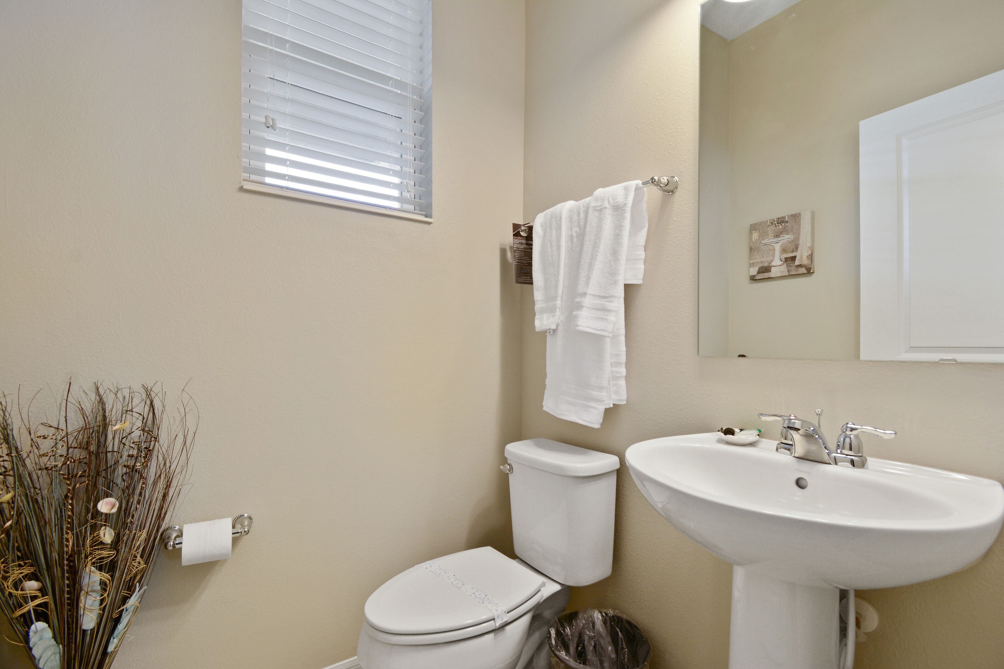Une salle de bain équipée de toilettes, d’un lavabo et d’un porte-serviettes.