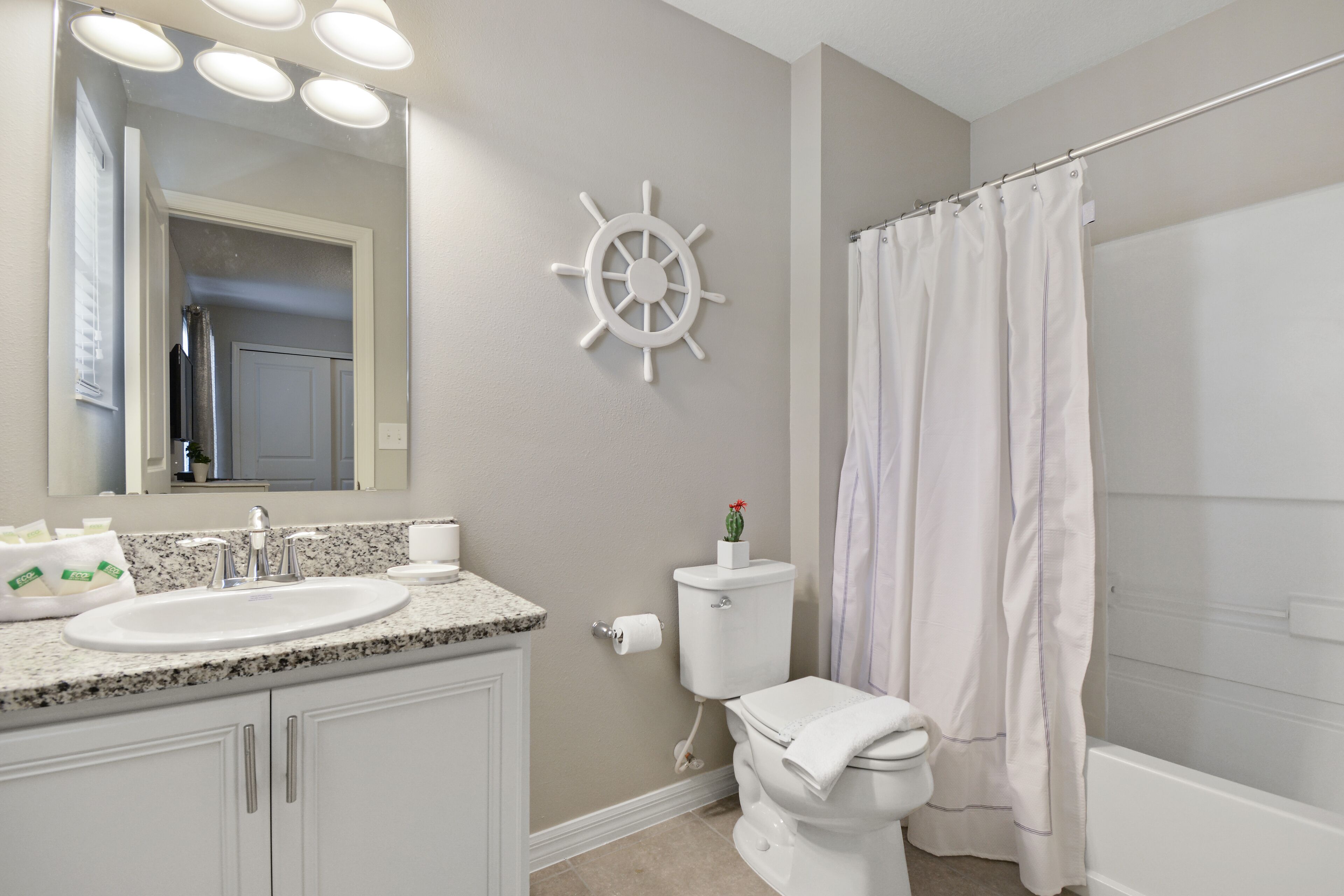 Une salle de bain équipée d’un lavabo, de toilettes et d’un rideau de douche.