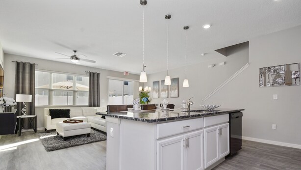 A modern kitchen with a central island, white cabinetry, and pendant lighting. - Four Bedroom GameRoom Compass Bay Resort 5128A (Kissimmee)