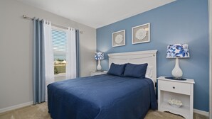 A bedroom with a large bed, two bedside tables, a nightstand, and a window with curtains. - Four Bedroom GameRoom Compass Bay Resort 5128A (Kissimmee)