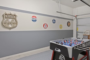 A room with a foosball table, a dartboard, and wall decals of various car brands. - Four Bedroom GameRoom Compass Bay Resort 5128A (Kissimmee)