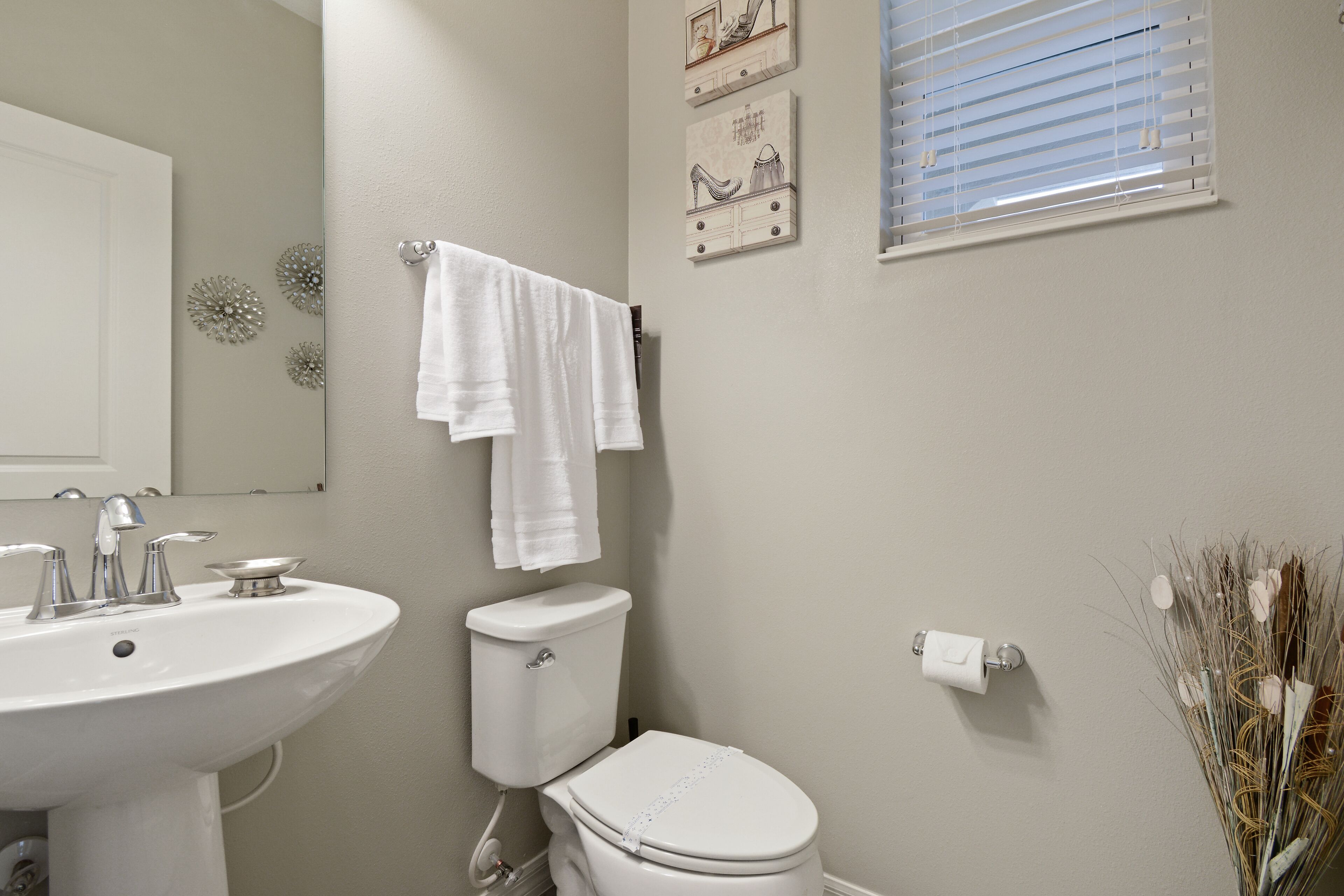 A bathroom with a white sink, toilet, and a towel rack.