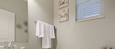 A bathroom with a white sink, toilet, and a towel rack.