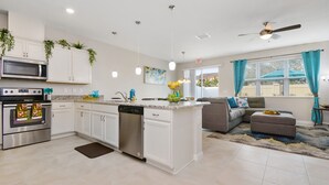 A modern kitchen with white cabinetry, stainless steel appliances, and a central island. - Amazing 4 Bedroom Close to Disney @Compass Bay Resort 5161 (Kissimmee)