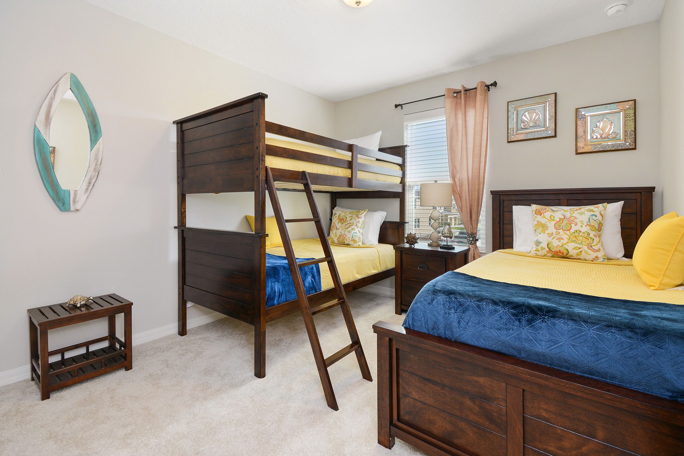 A bedroom with a bunk bed, a bedside table, a lamp, and a small side table.