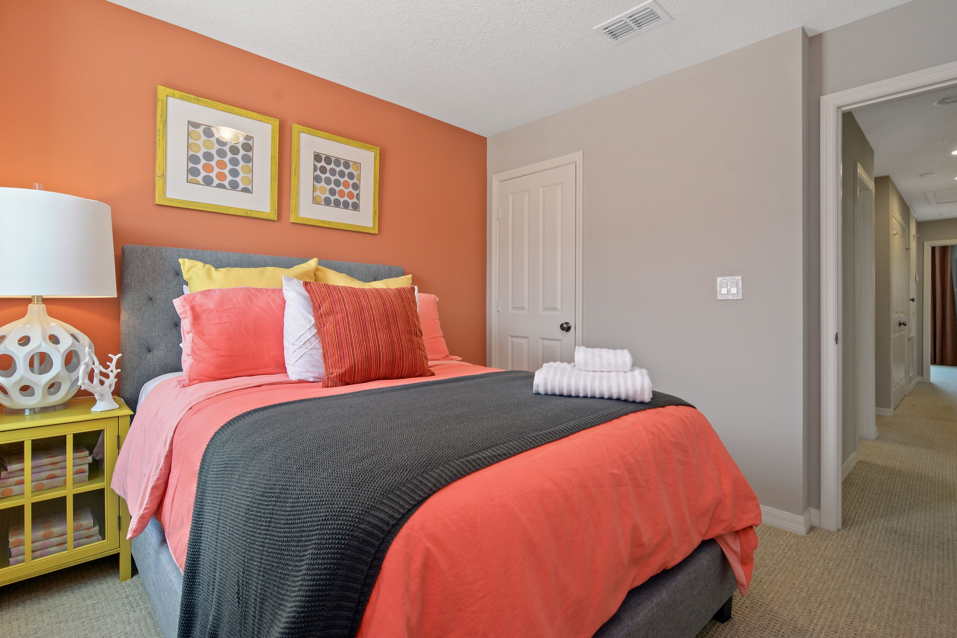 A neatly arranged bedroom with a bed, bedside table, and a door.