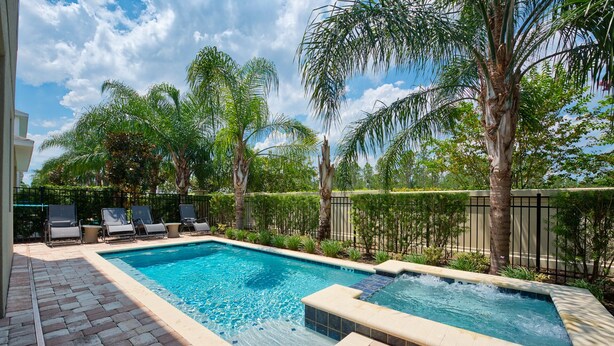 A rectangular swimming pool with a tiled edge, surrounded by a brick patio. There are lounge chairs and a small table near the pool. - Wonderful 8Bd w/ Pool & GameRoom @ Encore 461 (Kissimmee)
