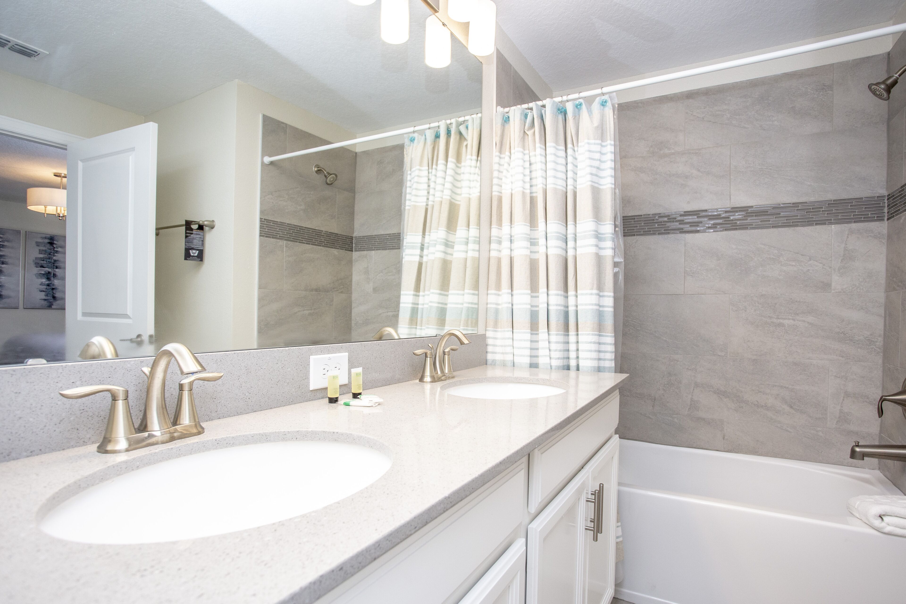 A bathroom with two sinks, a bathtub, and a shower.