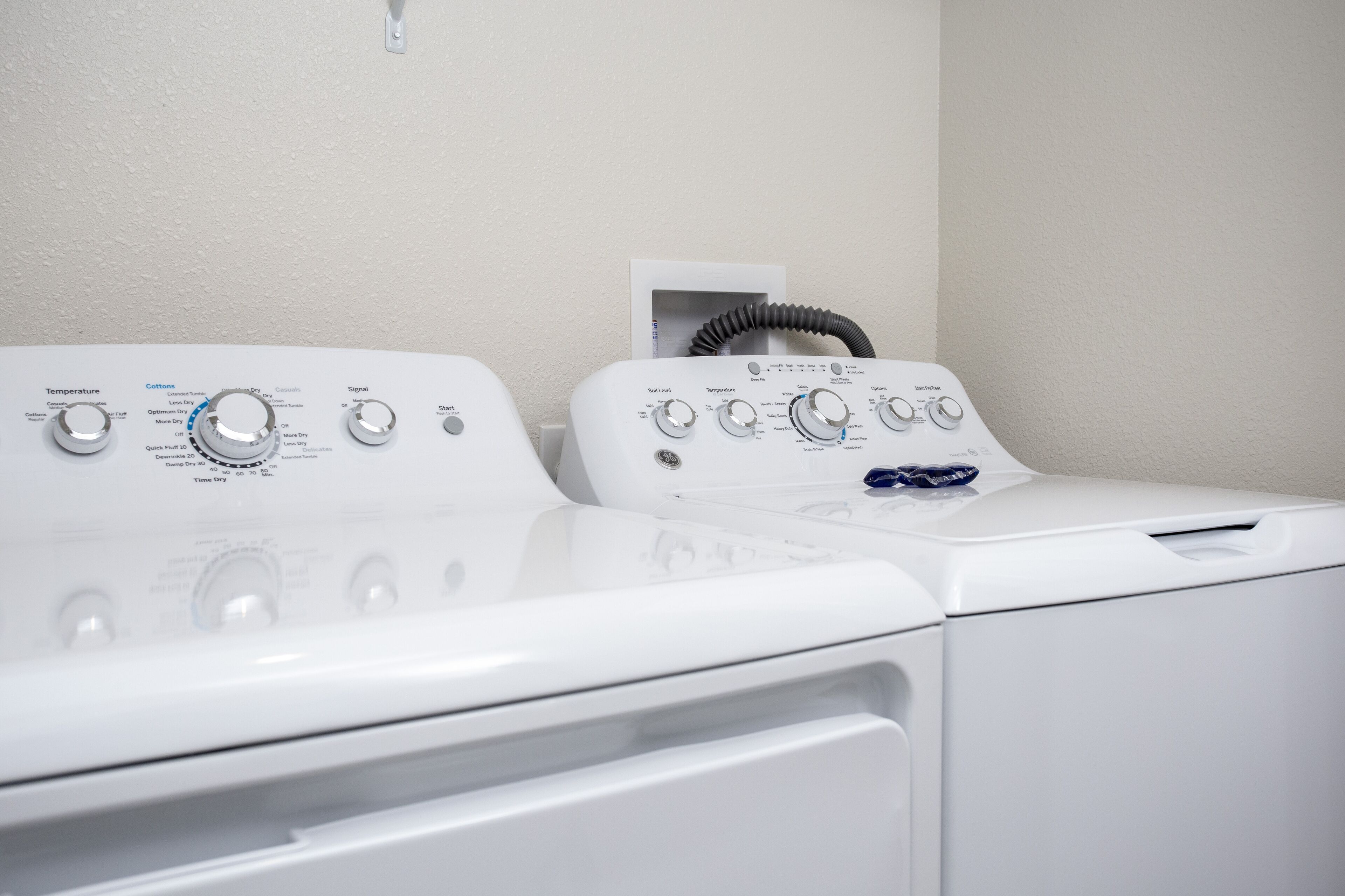 A front view of a laundry area with two stacked washers and dryers.