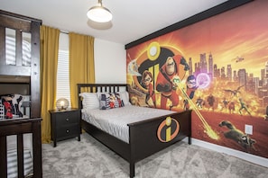 A bedroom with a bed, nightstand, and a mural of animated characters.