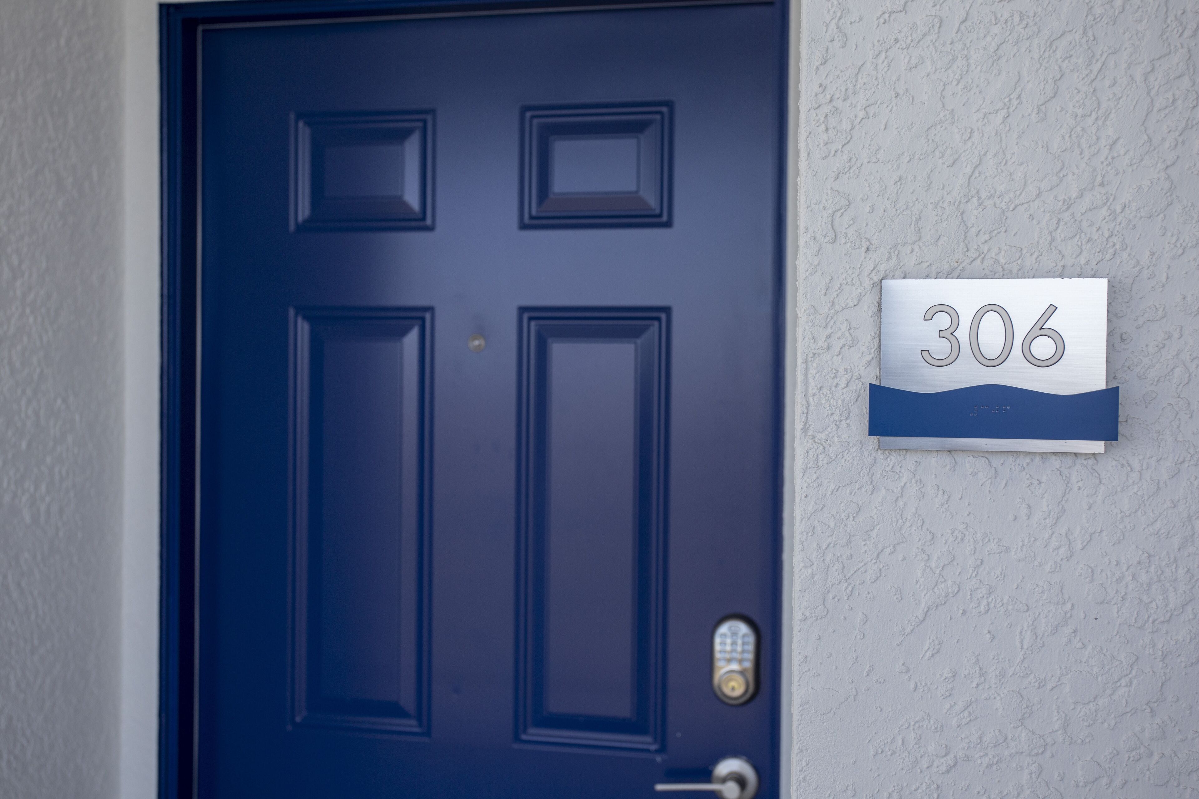 A dark blue door with a numerical sign indicating the number 306.