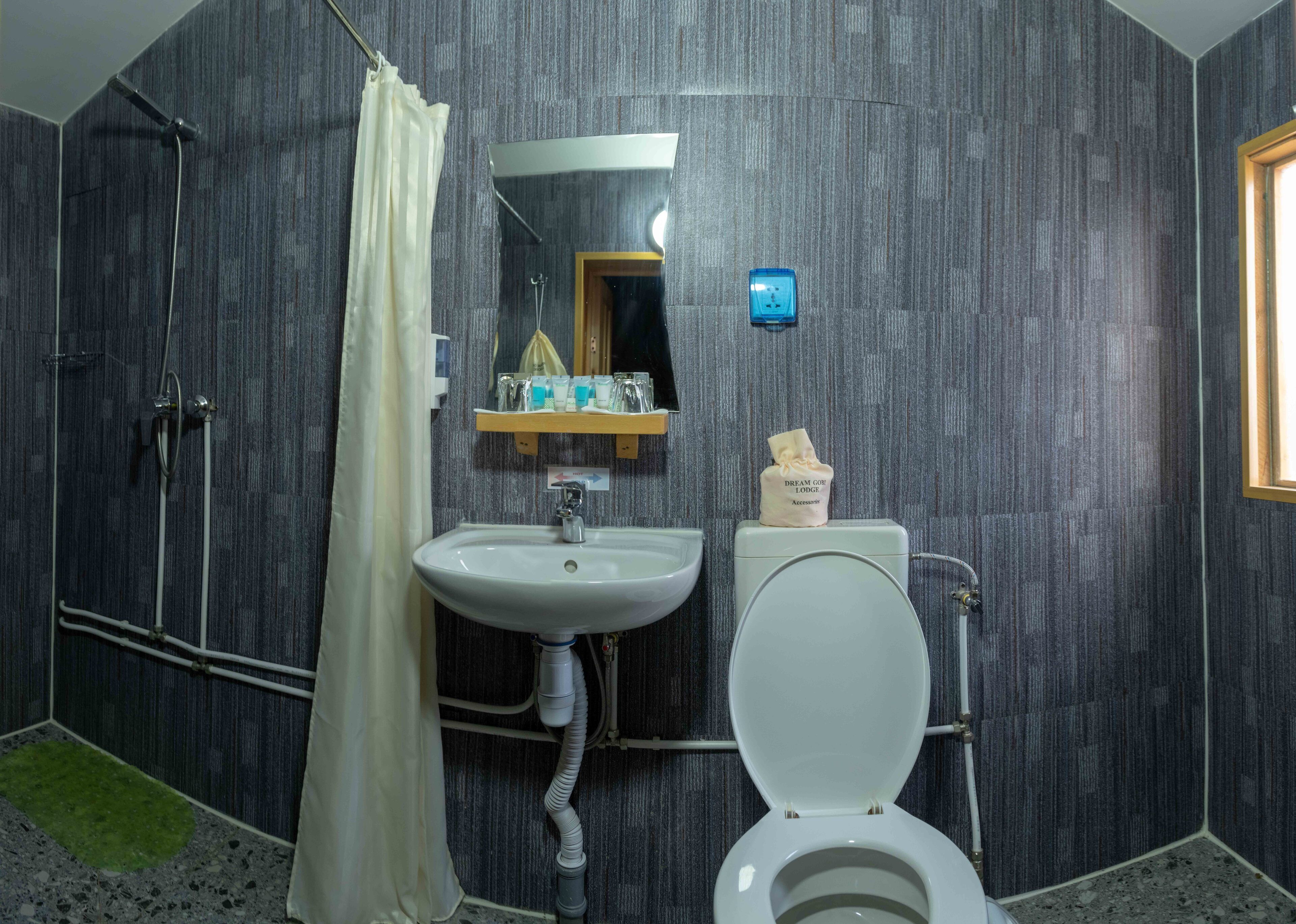 Un baño con ducha, lavabo e inodoro.