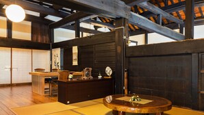 Une pièce de style japonais traditionnel, avec un sol recouvert de tatamis, une table en bois et une porte coulissante.