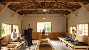 Une pièce traditionnelle en bois, dotée de tatamis, d’un autel central et d’un paravent shoji.