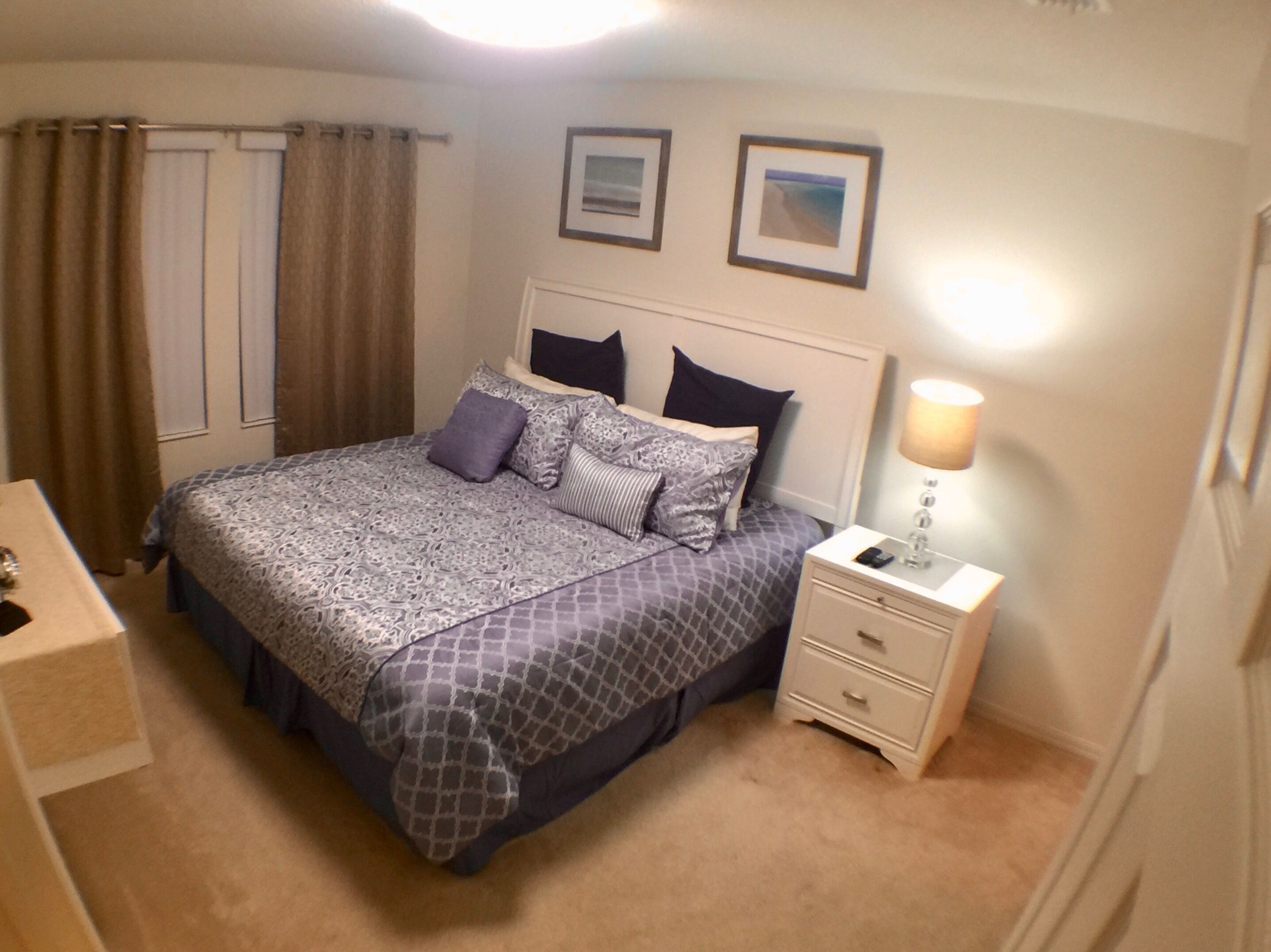 A neatly arranged bedroom with a bed, bedside tables, and a lamp.