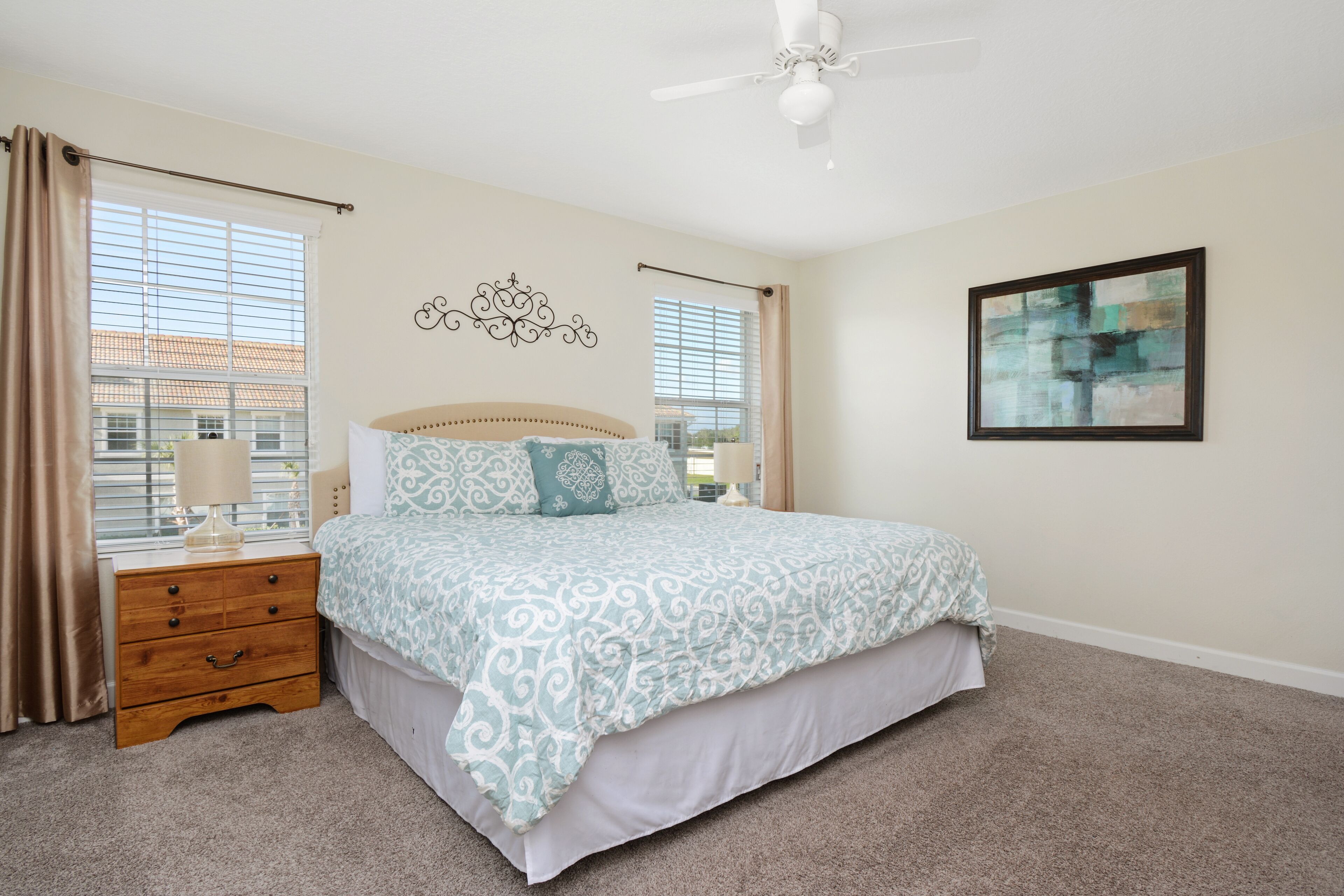 A bedroom with a bed, nightstand, and a ceiling fan.